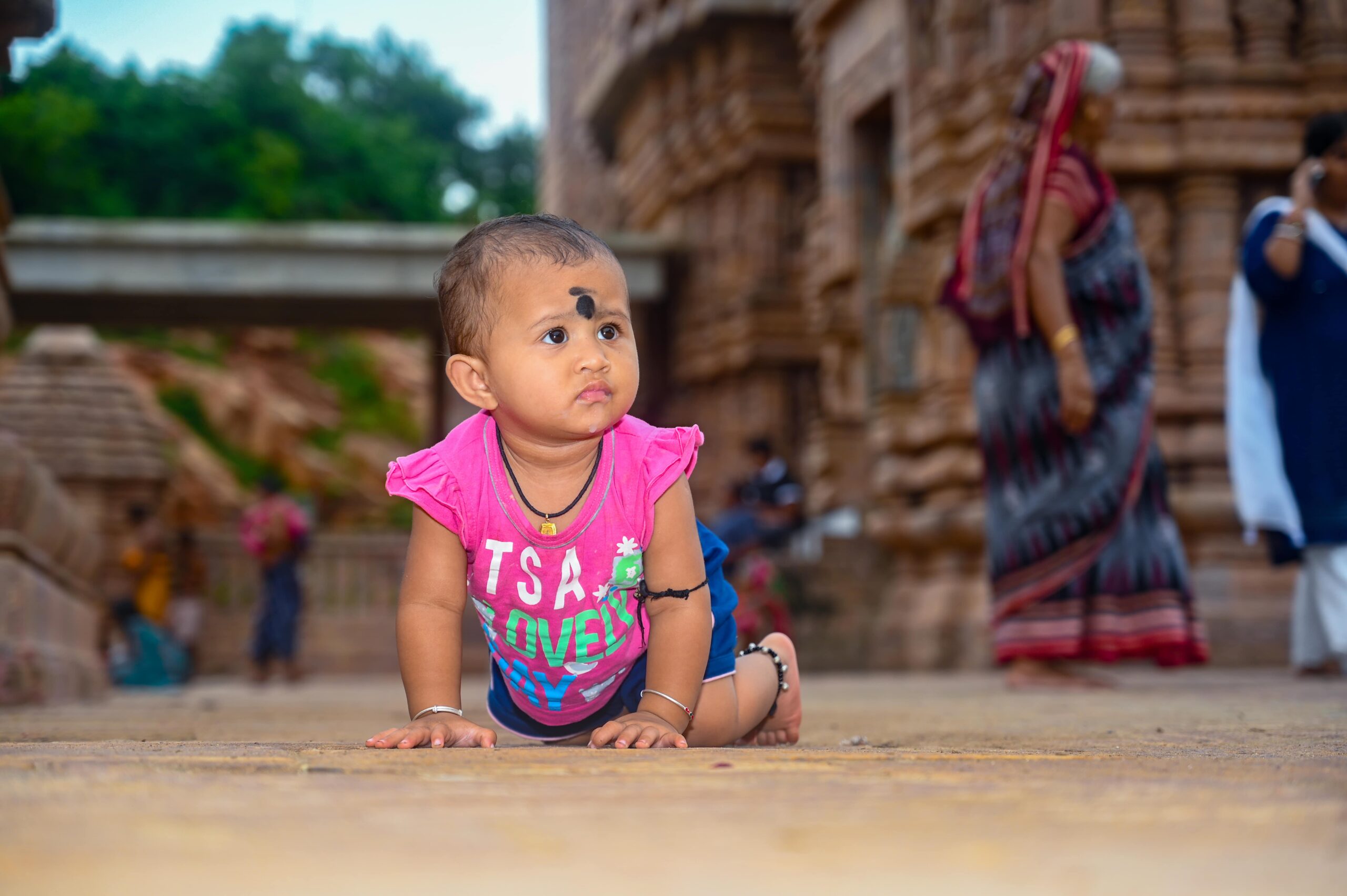 baby crawling stone structure traditional attire